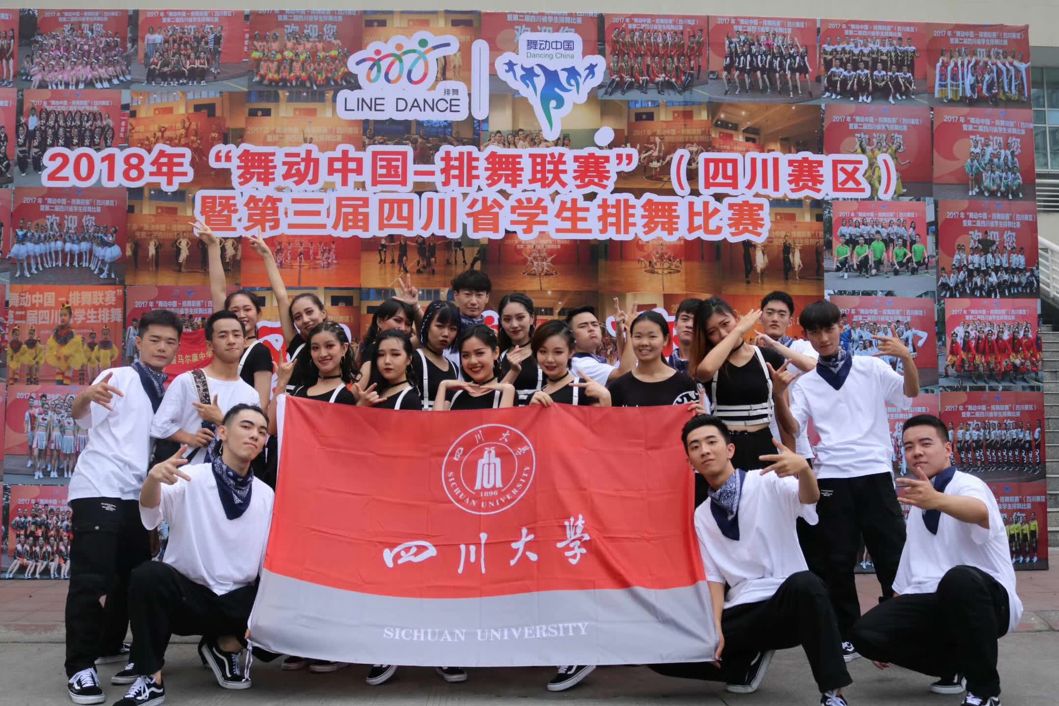 A dance team posing with a Sichuan University flag in front of the competition backdrop.
