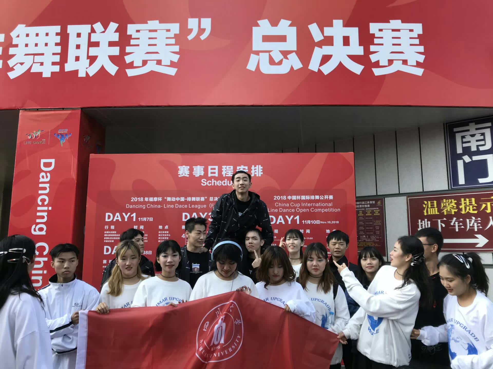 The dance team posing with a Sichuan University flag outside the national finals venue.
