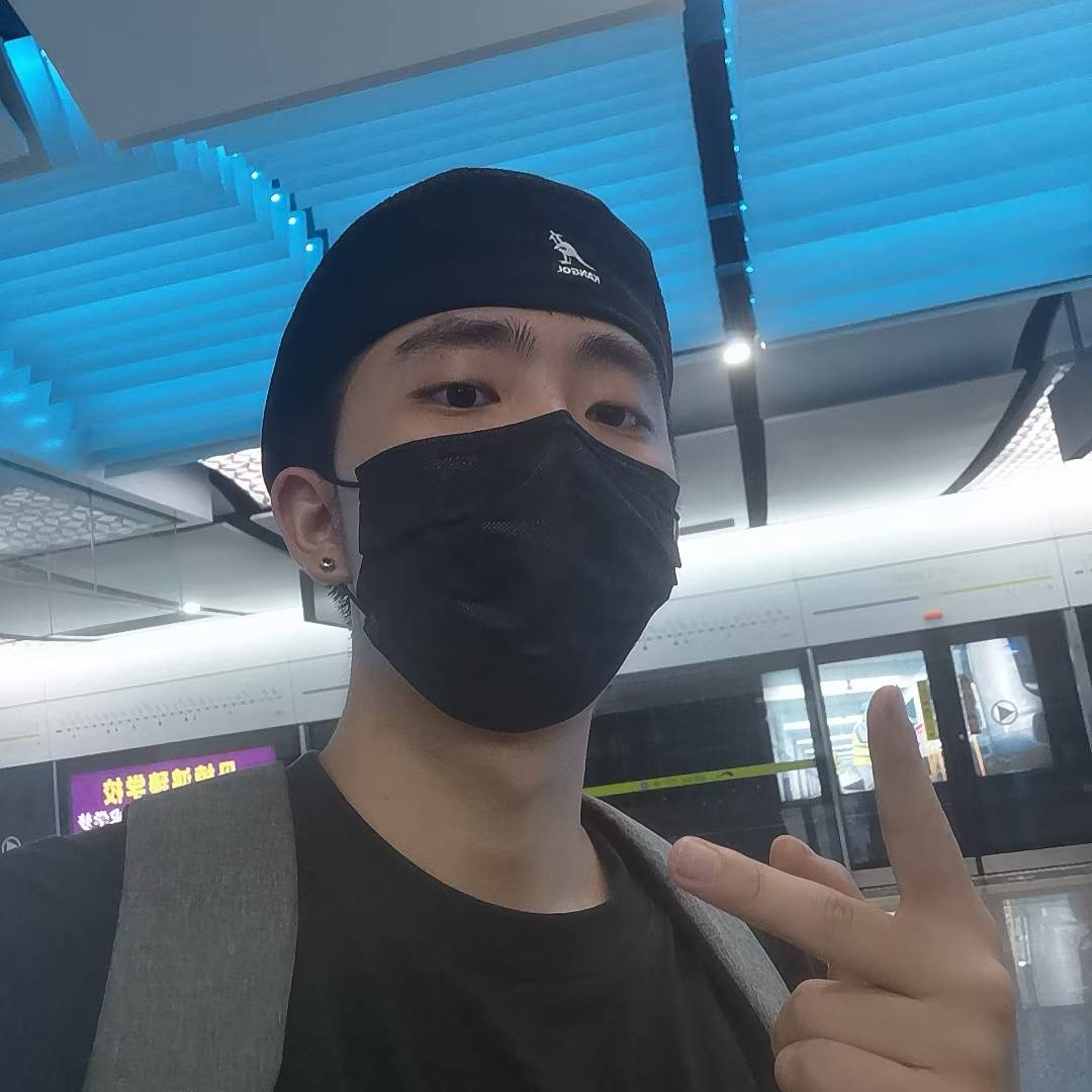 A selfie wearing a black cap, face mask, and backpack at a metro station.